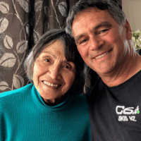 Jane and Duane Dixon smiling together, sitting closely and holding each other in a warm embrace.