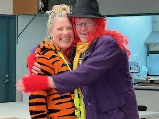 Two Hospice Whanganui clinical team members share a joyful hug during their annual planning retreat at Laird Park Bowling Club.