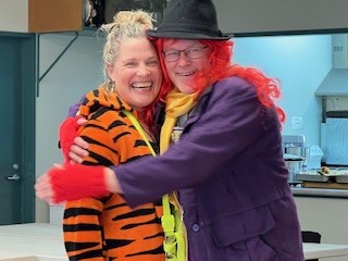 Two Hospice Whanganui clinical team members share a joyful hug during their annual planning retreat at Laird Park Bowling Club.