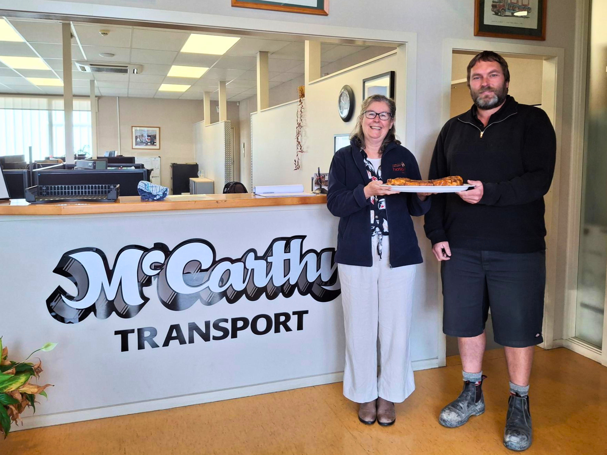 Hospice Whanganui Chief Executive Helen Leslie with a representative from McCarthy’s Transport at the McCarthy’s Transport office in Whanganui.