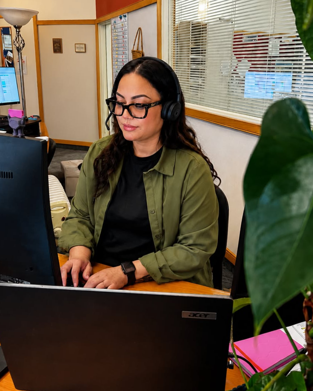 Hospice Whanganui staff member wearing a headset while working at her computer.